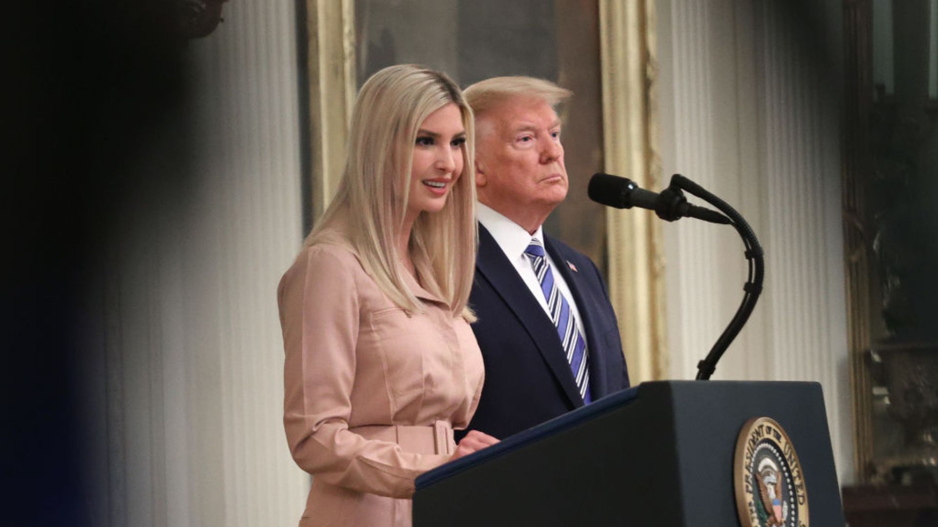 Donald Trump and Ivanka Trump stand side by side behind a lectern with the presidential seal