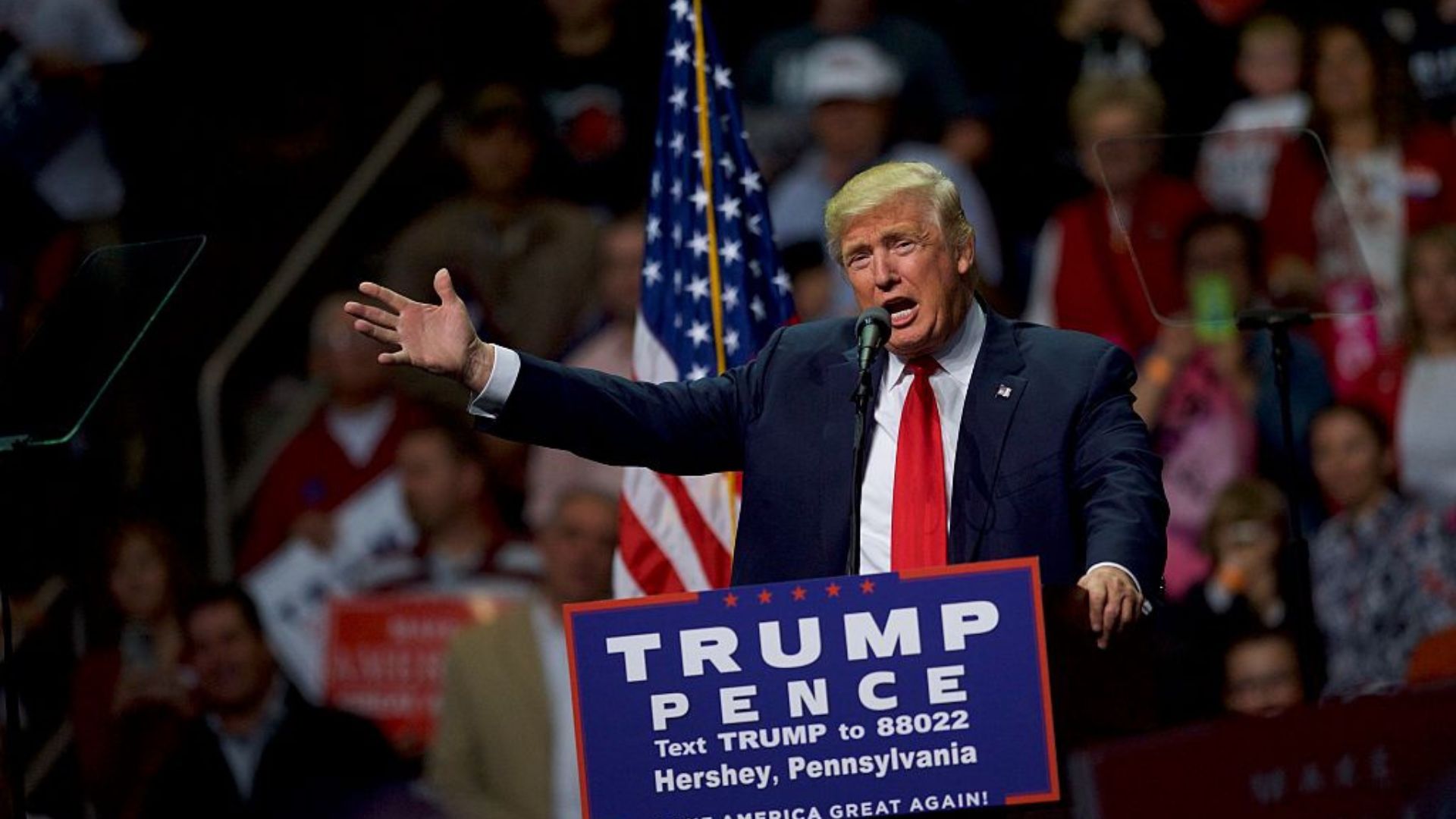 Former President Donald Trump actively speaking at a rally in front of a crowd