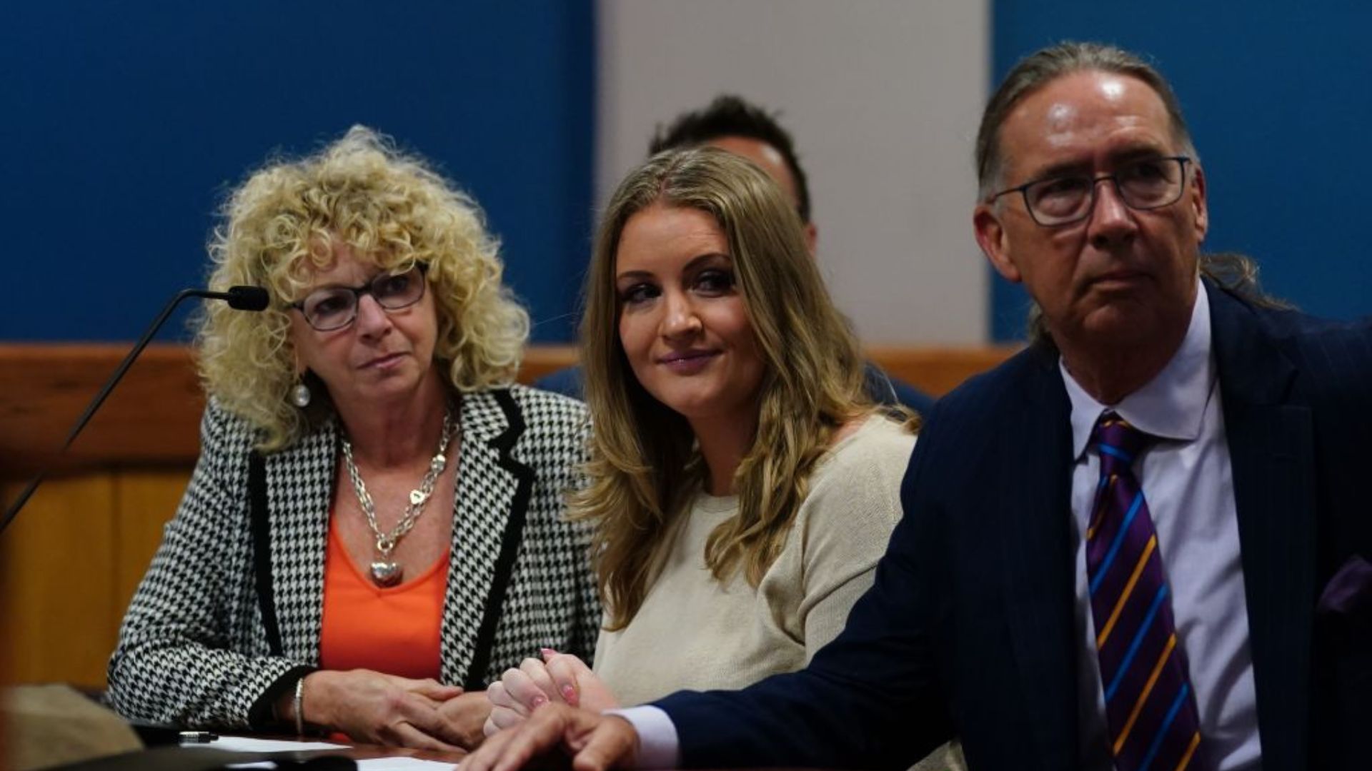 Jenna Ellis, seen in the center, seated alongside two individuals in a room that appears to be a courtroom