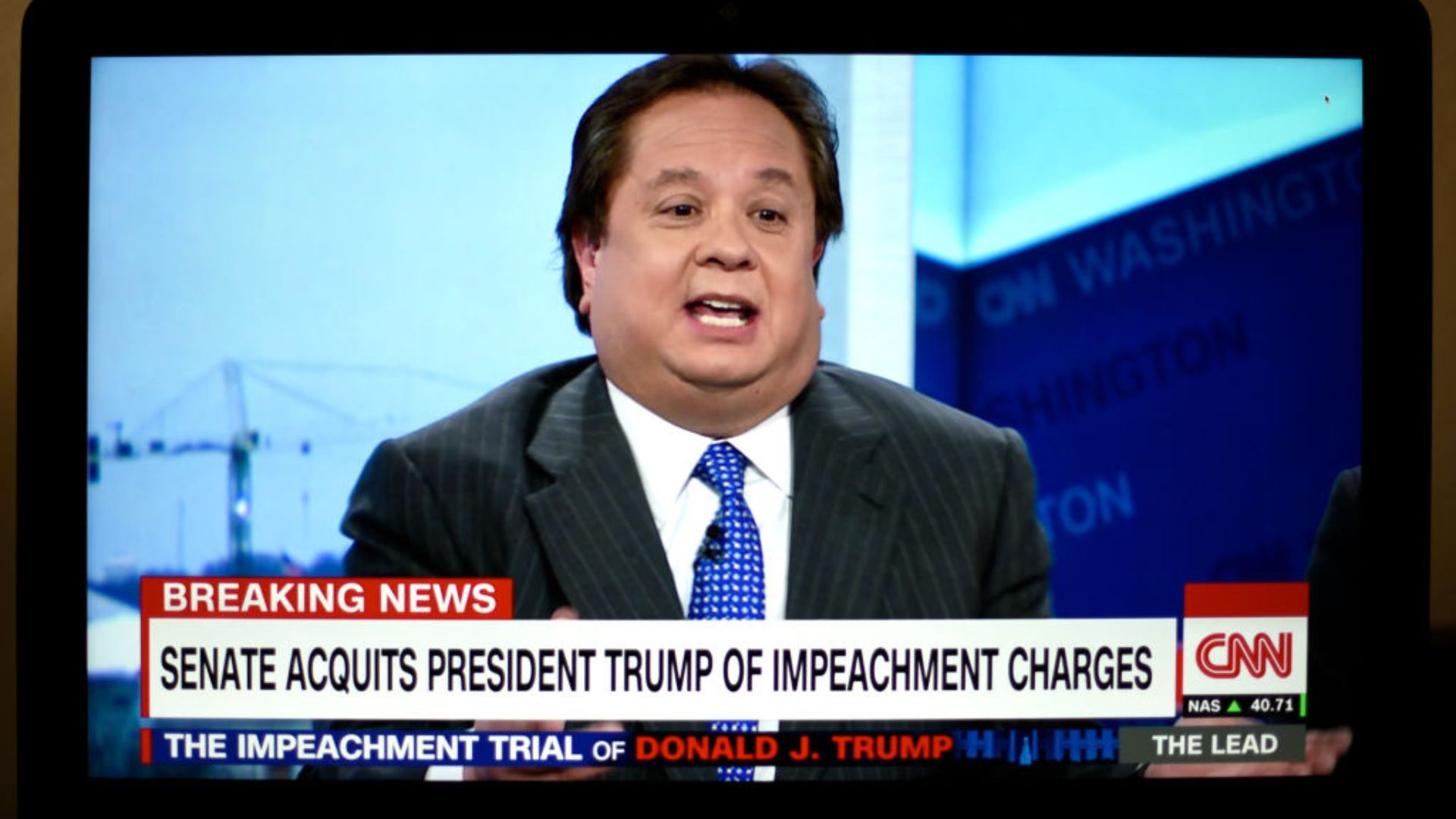 George Conway, wearing a dark suit and blue tie, speaking on CNN with the headline 'BREAKING NEWS: SENATE ACQUITS PRESIDENT TRUMP OF IMPEACHMENT CHARGES' displayed below. The background showcases a view of Washington and CNN logos