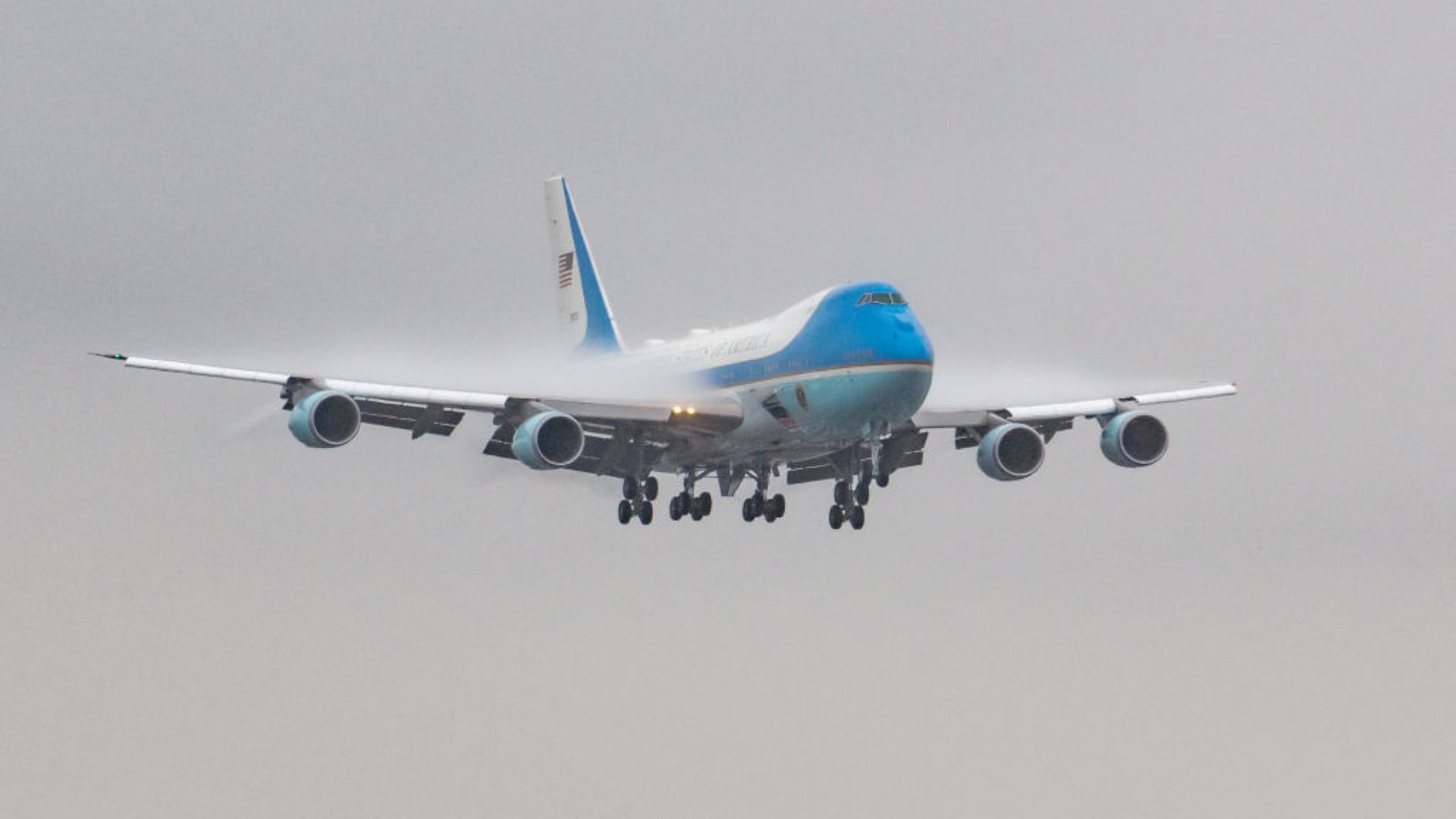 Air Force One in the process of descending against a hazy gray sky