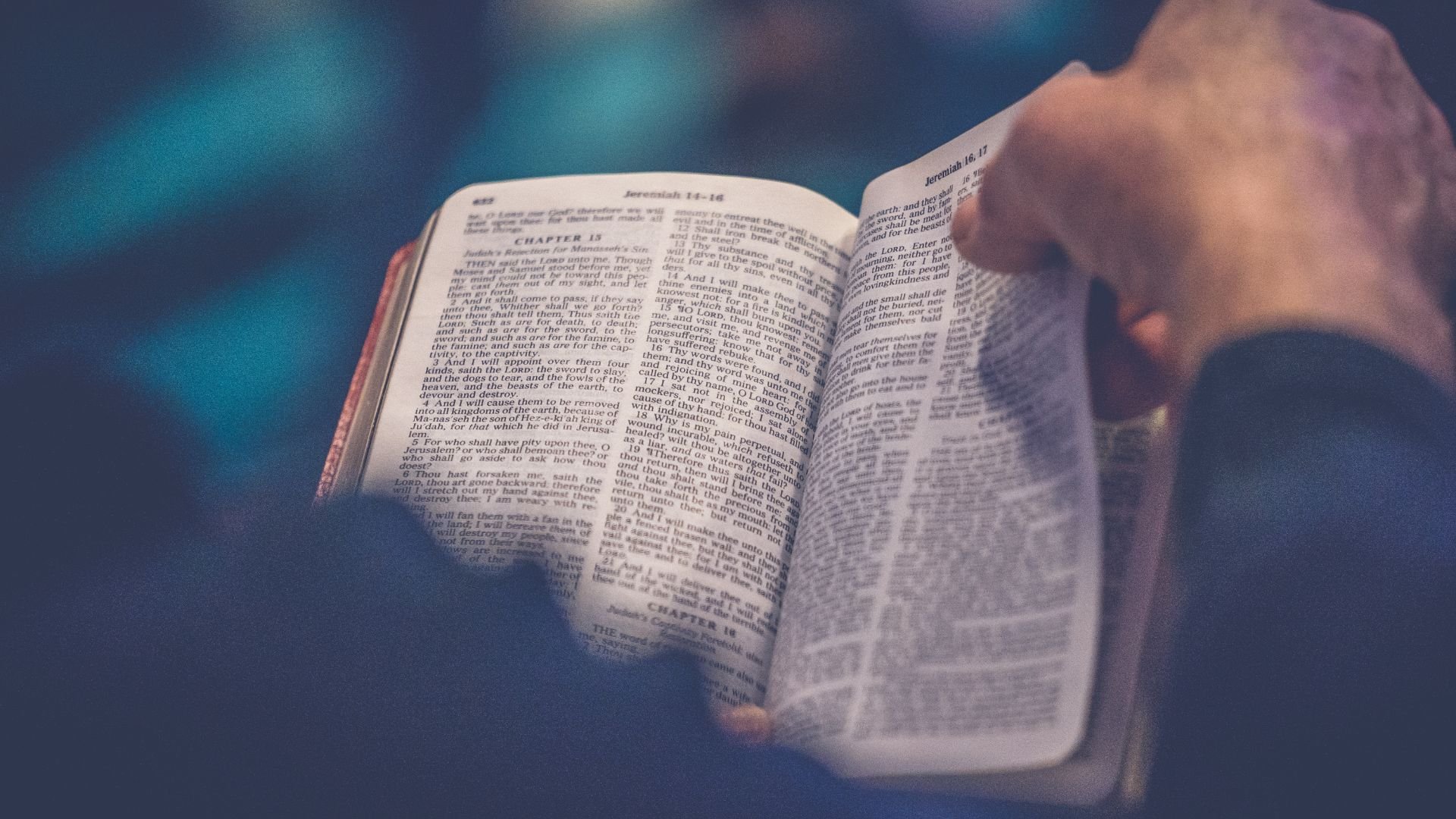 close-up of hands holding open a Bible to the book of Jeremiah
