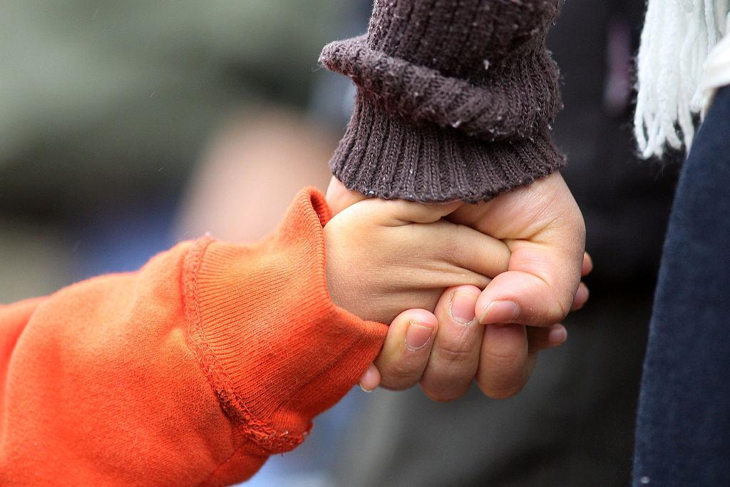 Claudia Garcia holds her son’s hand at shrine for the victims of Sandy Hook Elementary