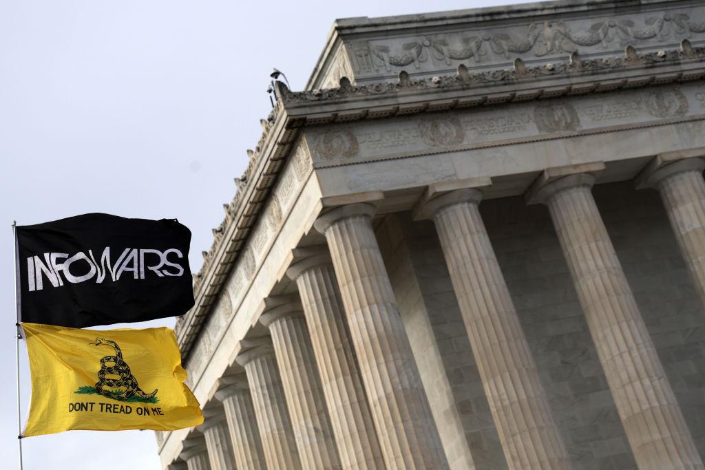 The flag of InfoWars flies at an anti-vaccination rally