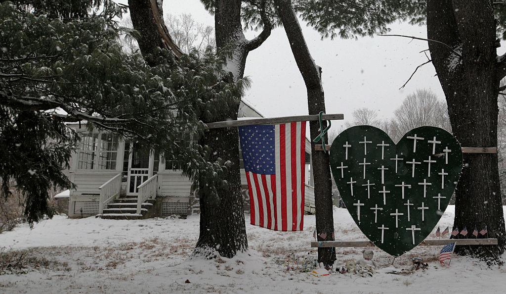 A memorial with crosses for the victims of the Sandy Hook massacre stands outside a home in Newtown, CT