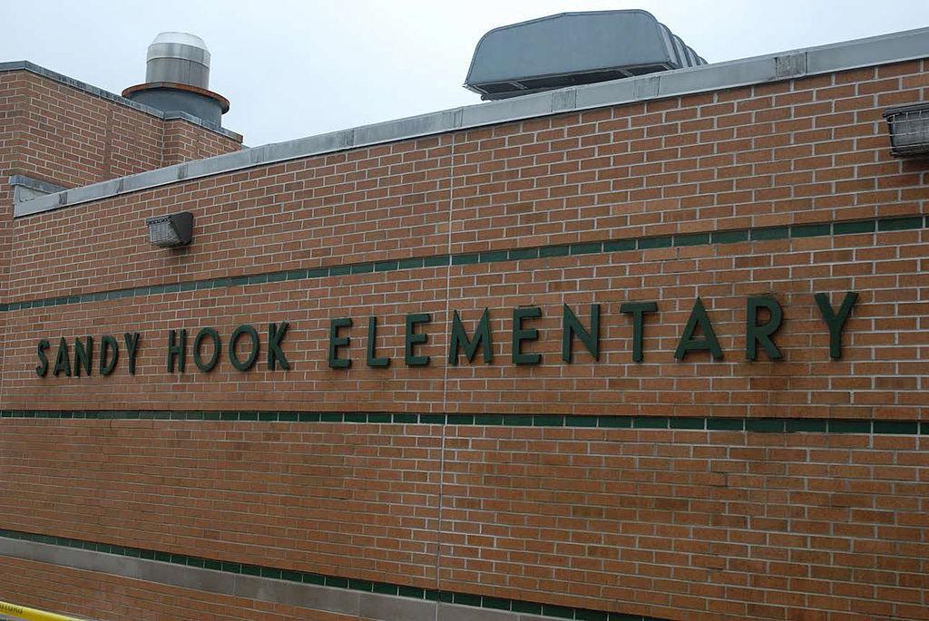 Brick wall of Sandy Hook Elementary with the school’s name in black block letters