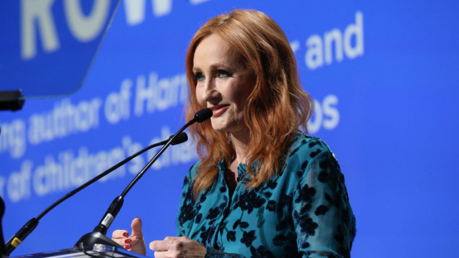 J.K. Rowling, the renowned author, is captured mid-speech at a public event