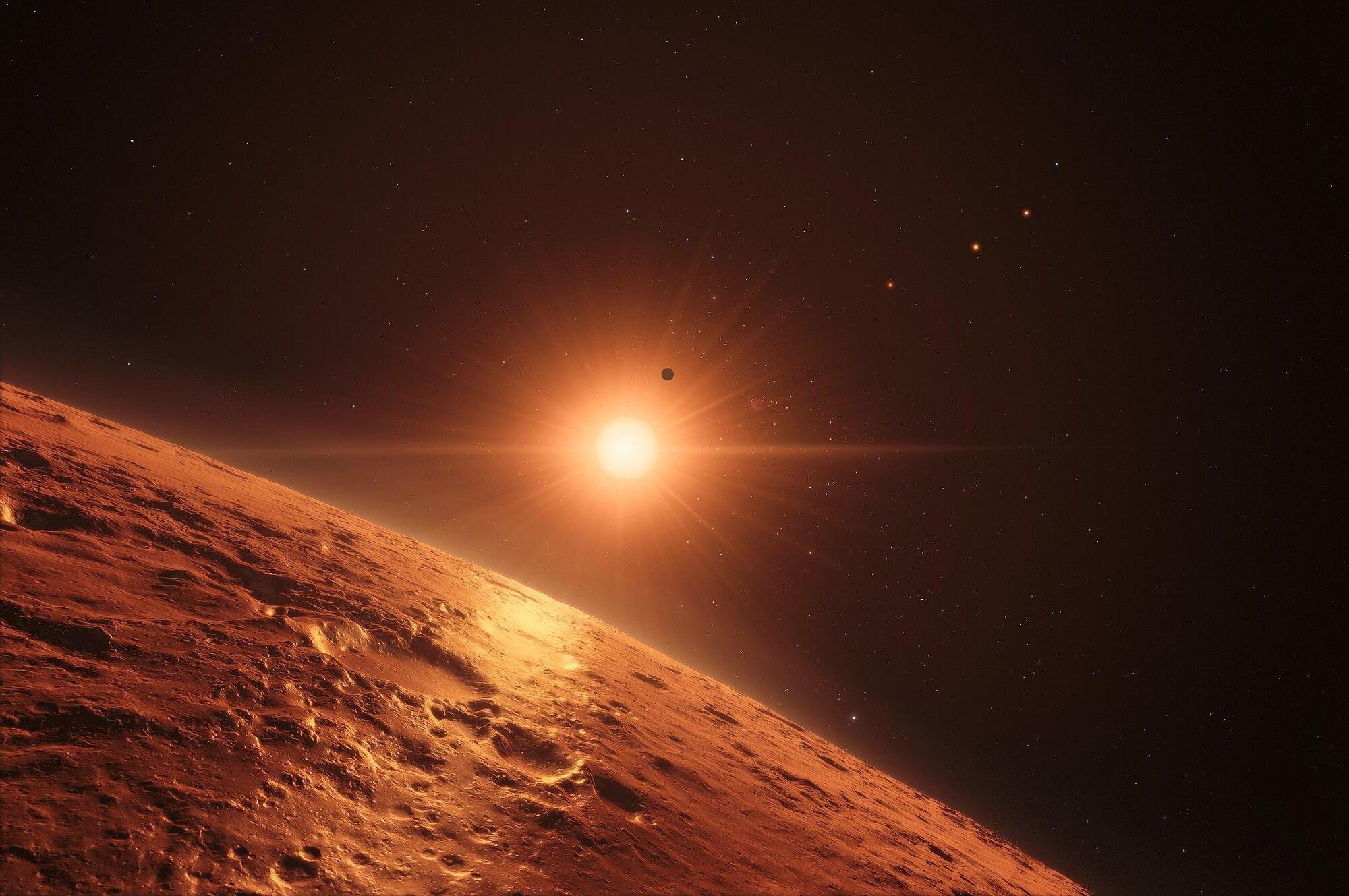 A view of a section of a planet with a rocky surface and a sun shining behind it.