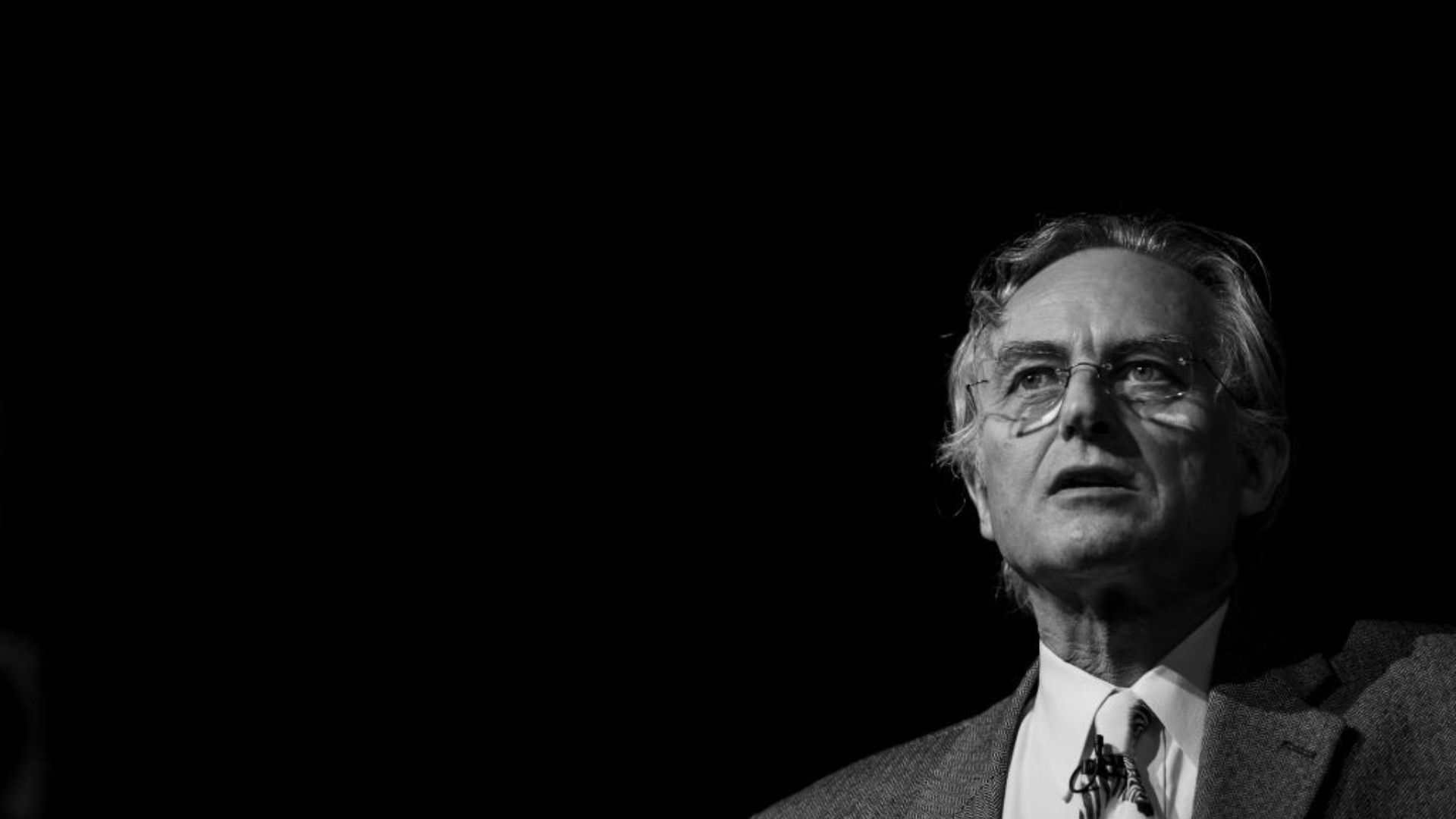 A black and white photograph showcasing Richard Dawkins, renowned evolutionary biologist and author