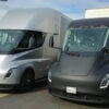 A photograph of two large electric semi-trucks produced by Tesla